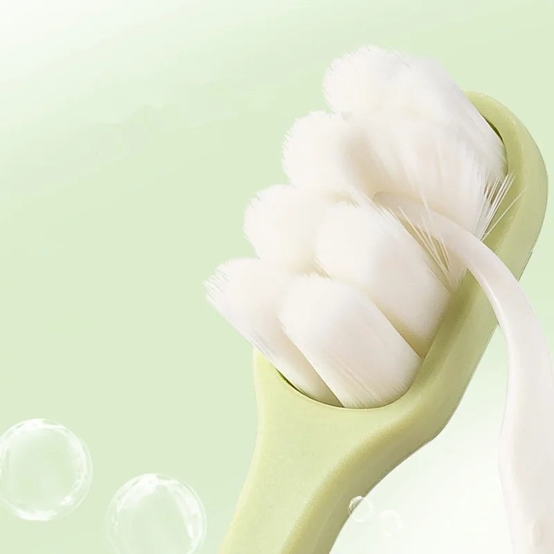 Une brosse à dents vert clair avec des poils blancs doux, présentée sur un fond vert pâle.