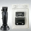 A black hair clipper replacement blade is shown next to its clear plastic packaging.