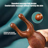 A close-up of a polished brown sandalwood massage ball with a smooth, rounded design being held in a hand.