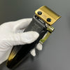 Eine Hand hält eine gold-schwarze Profi-Rotationshaarschere mit Messing-Einsatz.
