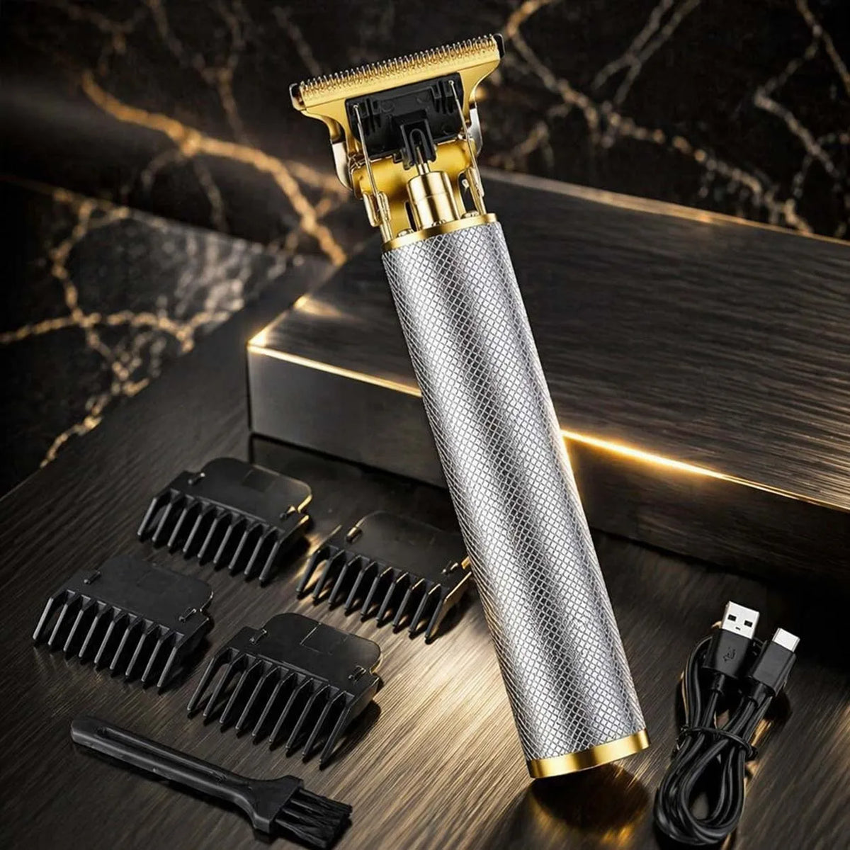 A professional cordless hair clipper set with a silver body and gold accents is displayed on a dark wooden surface.