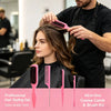 A woman is being styled by a man using a pink and green all-in-one comb and brush kit for professional hair styling.