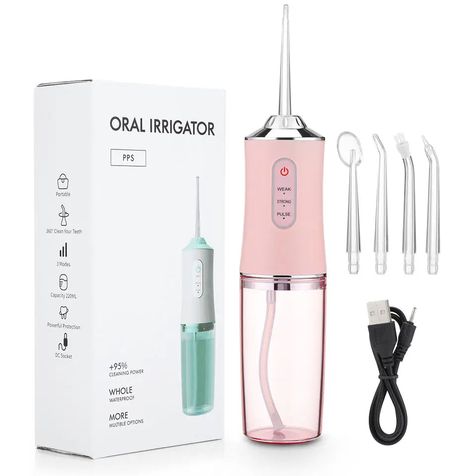A pink oral irrigator device with a green tip and charging cable is shown next to its packaging box.