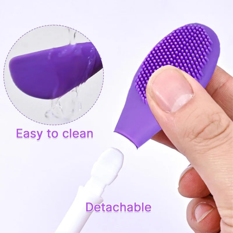 A purple silicone facial brush set with a detachable white handle and a purple exfoliating head being held by a hand.