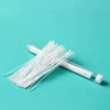 Tubo transparente lleno de agujas desechables para limpieza de perforaciones, sobre fondo verde azulado.