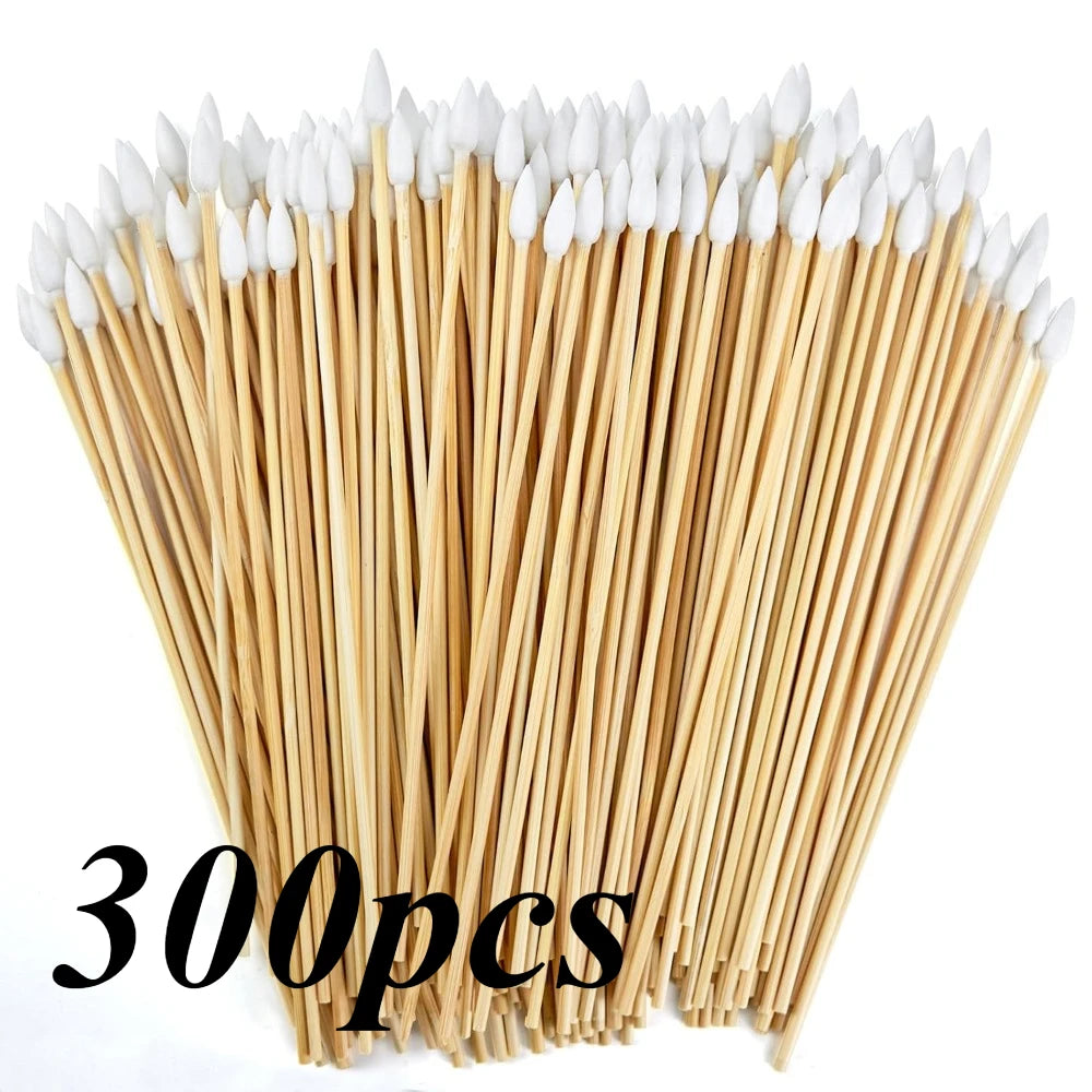 Un lot de 300 cotons-tiges réutilisables à manche en bois avec des embouts blancs.
