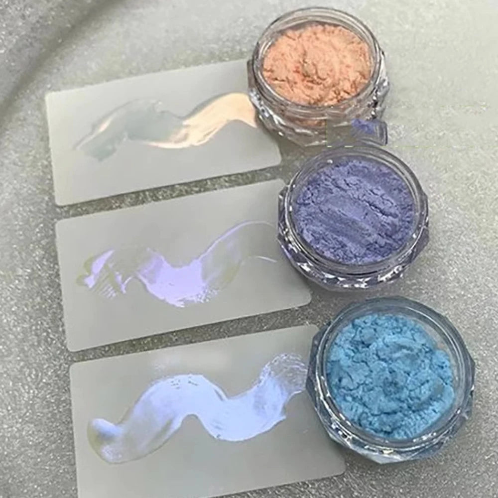 A collection of glitter powders in various shades including pink, purple, and blue displayed on clear cards.