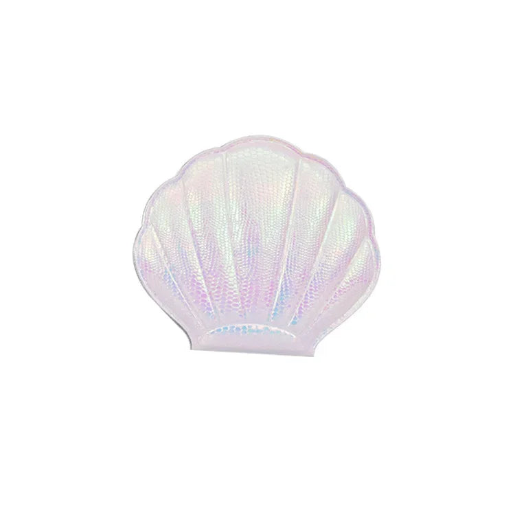 A light pink, iridescent seashell-shaped portable magnifying makeup mirror.
