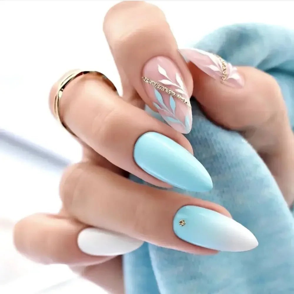 A hand displays press-on false nails with a light blue French wavy design on the index and middle fingers.