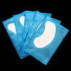 A stack of blue under-eye lash application patches is shown against a black background.