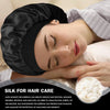 A woman is sleeping wearing a black silk bonnet for hair care.