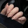 A hand displaying pink flower almond press on nails against a dark background.
