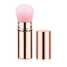 A set of rose gold retractable makeup brushes, including a large pink brush and a cylindrical holder.