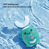 A teal silicone toy shaped like a smiling face is floating in clear water with an attached U-shaped silicone piece.