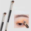 A double-ended eye shadow brush with a smudge tip and blending shader shown next to an eye.