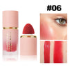 A tube of liquid matte blush and a round stick applicator in coral pink packaging with a red product shown next to an eye swa