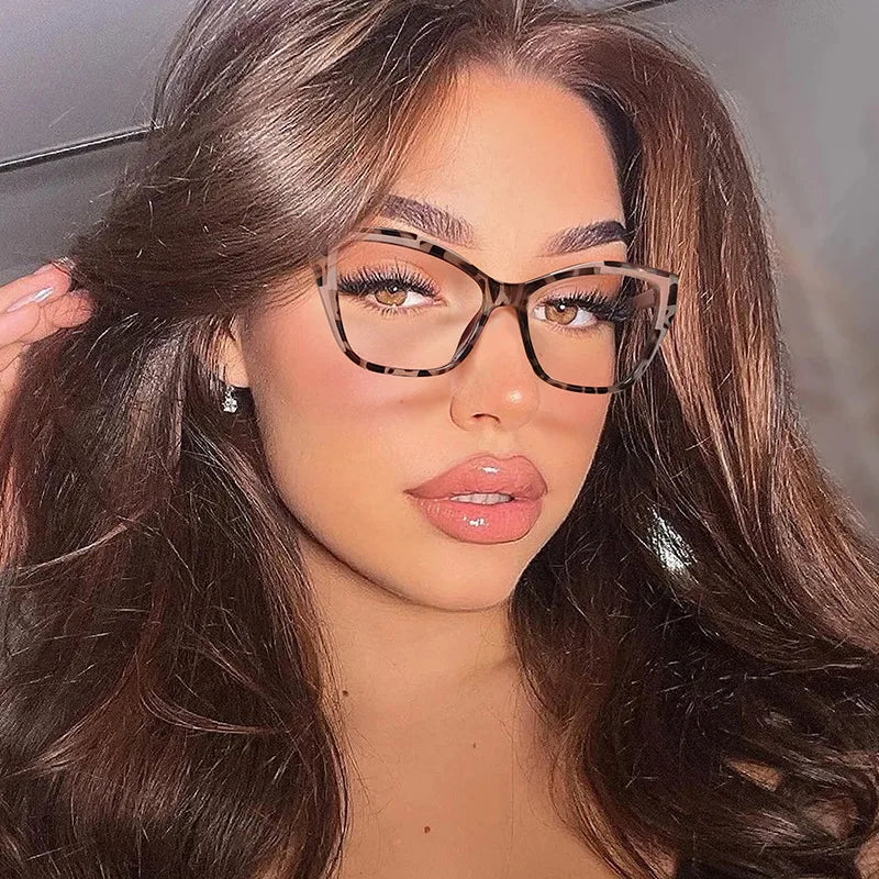 A close-up portrait of a woman wearing elegant cat eye anti-blue light reading glasses with brown hair.