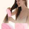Une femme utilise un peigne pour cheveux teinté et lissé pour masser, coiffer et lisser ses cheveux.