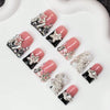 Un set de uñas postizas Y2K con diseños de cristal y estrellas en tonos rosa y negro.