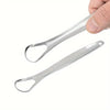 Une main tient un kit de rasoirs en acier inoxydable pour le nettoyage de la langue.