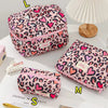 Pink leopard print quilted cotton makeup bag with zipper closure displayed on a white surface.