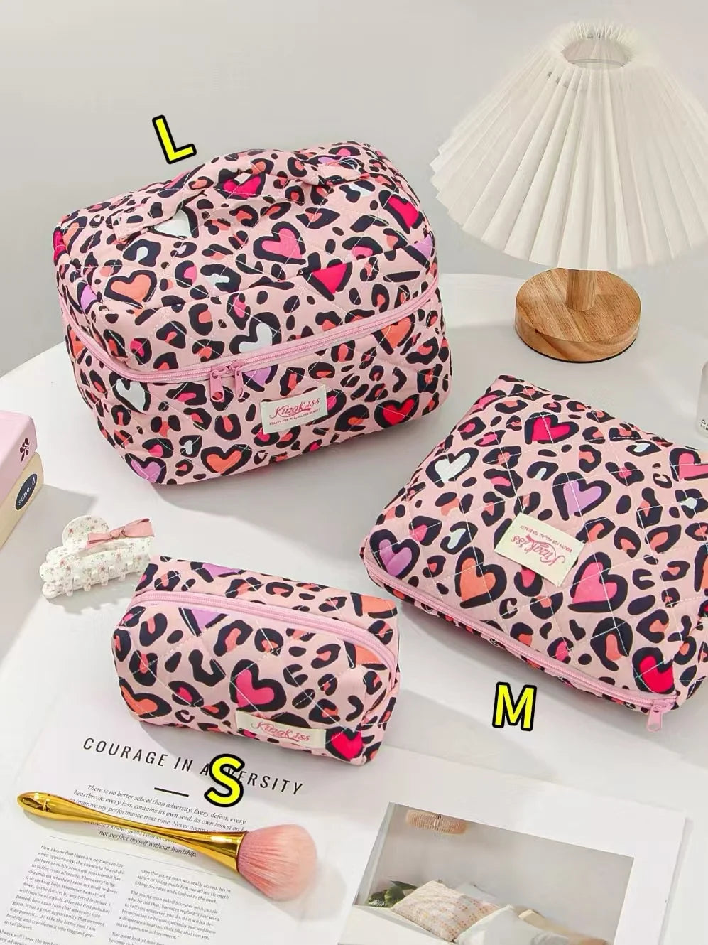 Pink leopard print quilted cotton makeup bag with zipper closure displayed on a white surface.
