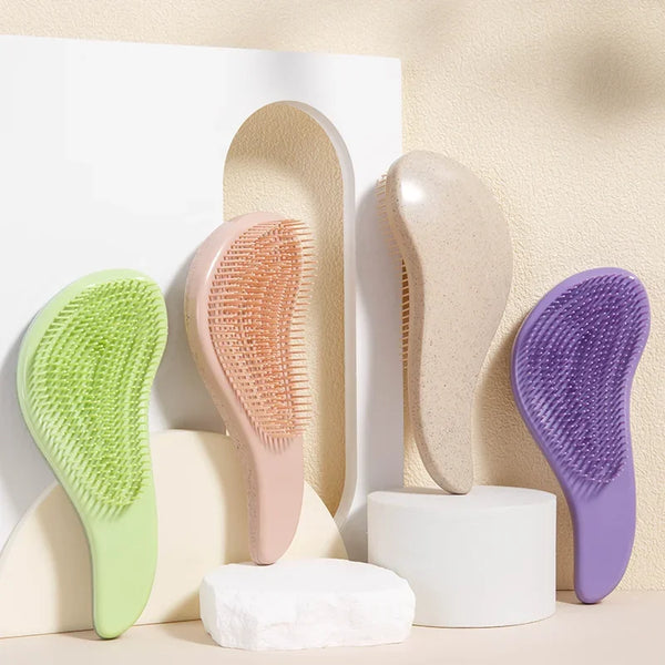 A collection of light-colored silicone detangling scalp massage hairbrushes in various shades of green, pink, beige, and purp