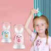 A young girl is holding a U-shaped electric toothbrush for kids with a pink and teal design against a light pink background.
