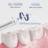 A white portable water flosser is shown cleaning a white tooth model with pink liquid.