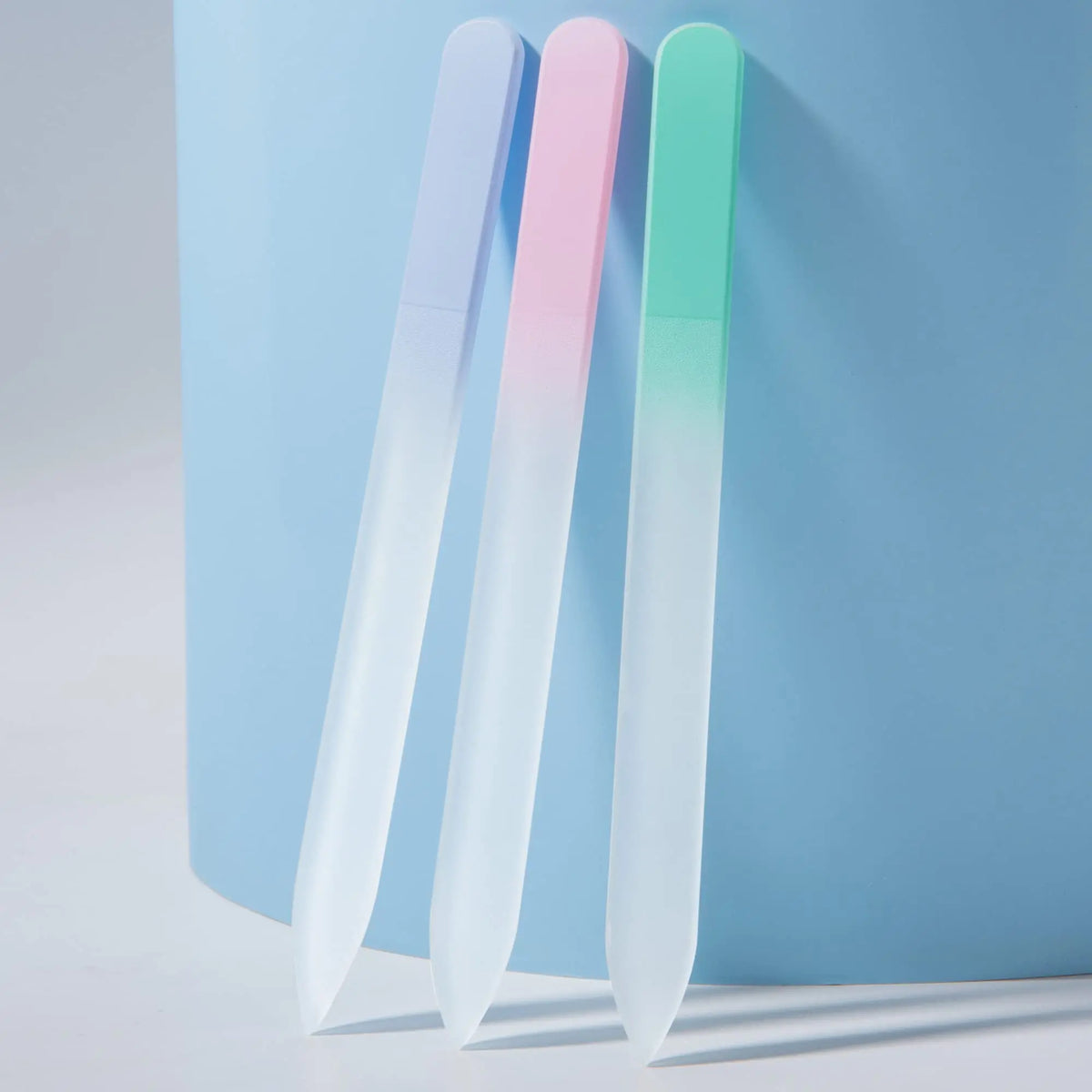 A set of four double-sided etched glass nail files in pastel colors, including pink, light blue, and mint green.
