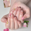 A hand displays pink French manicure press-on nails featuring polka dots and silver bead accents.