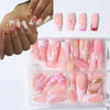 Colección de uñas postizas de flores en gel rosadas y blancas, mostradas en una bandeja de plástico transparente.