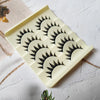 A rectangular white tray holding five pairs of black cat eye false eyelashes