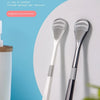 A white reusable tongue coating cleaner brush is shown against a light blue background.