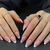 A set of 24 white French style coffin shape press-on nails being held by a person's hand.