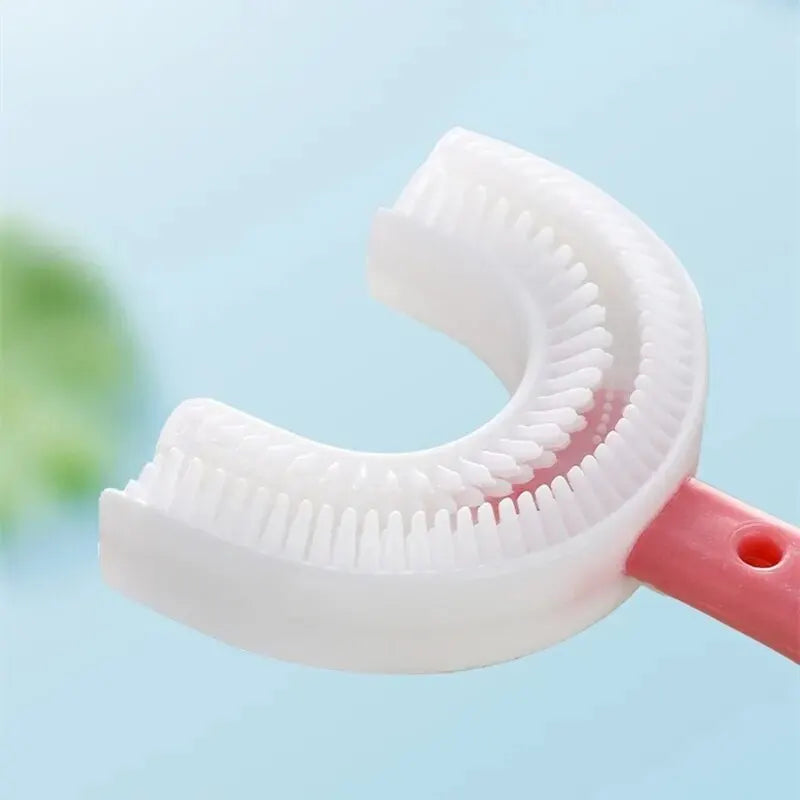 A white U-shaped silicone toothbrush is shown against a light blue background.