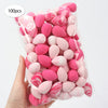 A hand holds a clear bag filled with 100 pink and white reusable expandable makeup sponges.