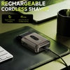 A portable rechargeable cordless shaver resting on a dark green leather mat next to a laptop.