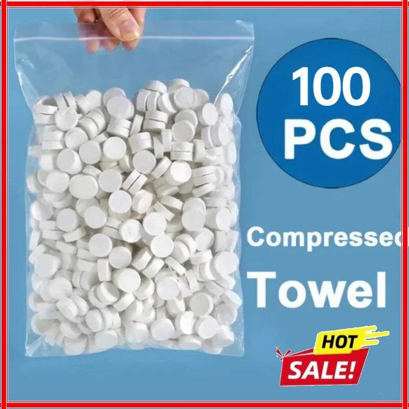 A clear plastic bag filled with 100 white compressed face towels for travel and outdoor use.