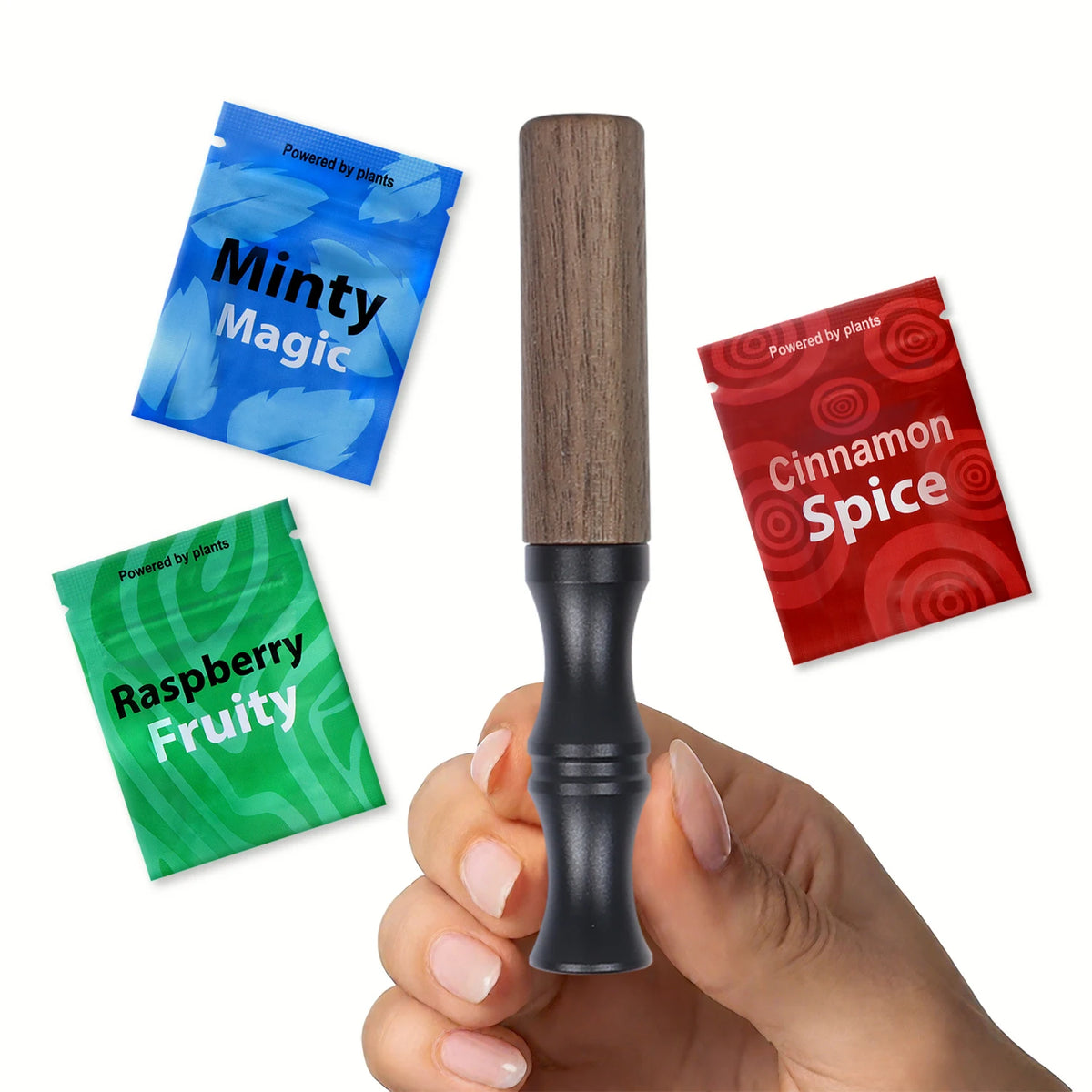 A hand holds a natural wooden stop smoking stick diffuser with a black base, surrounded by three plant-based flavor packets.