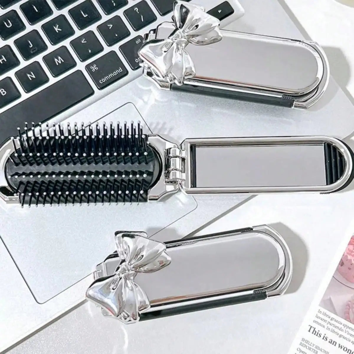 Silver portable compact comb with an airbag feature and a mirror displayed on a white background.