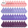 A set of purple cosmetic powder puffs arranged in four rows, showing various shades of purple and pink.