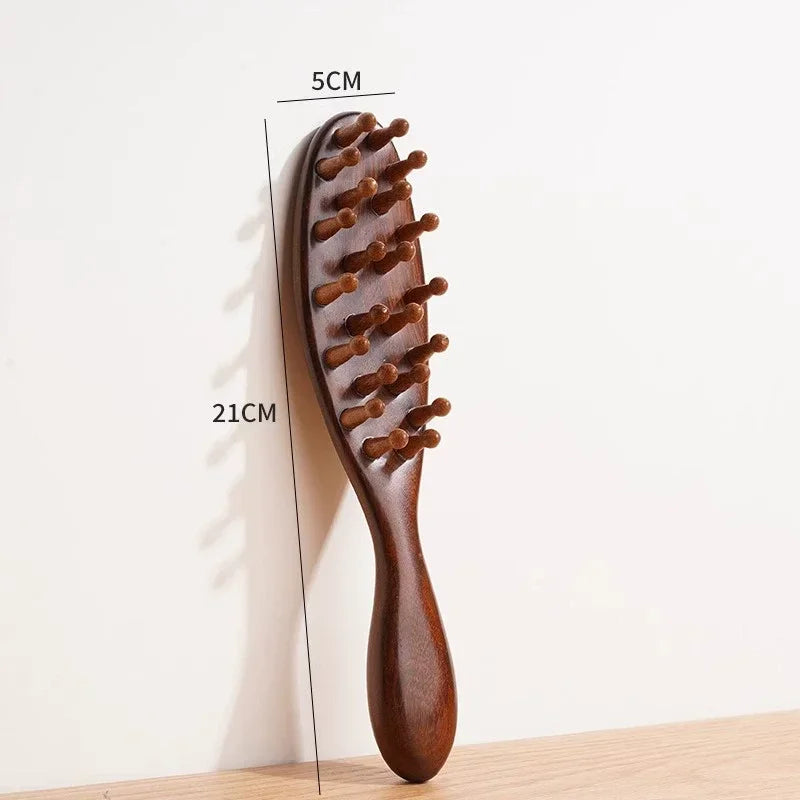 A wooden massage comb with numerous small, rounded teeth is shown against a white background.