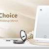 A white LED rechargeable travel makeup mirror with a 10X magnification lens displayed on a light surface.