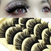 A close-up of a model's eye showcasing long, thick black false eyelashes.