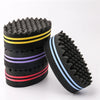 A stack of black hair braiding brushes with yellow and purple stripes.