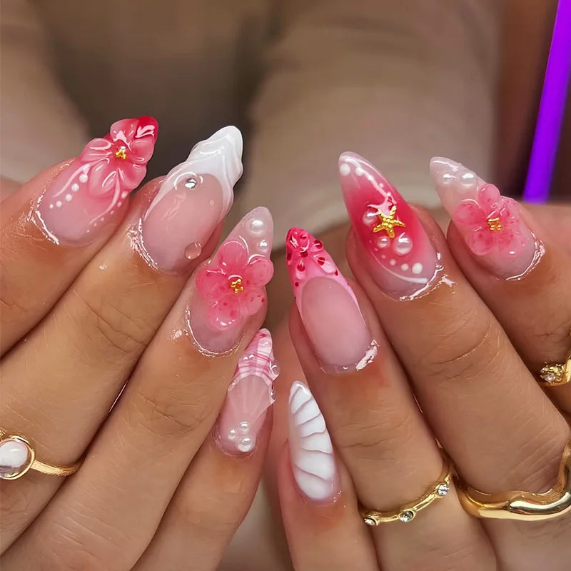 Gros plan sur des mains présentant un ensemble de faux ongles à presser roses français avec des accents floraux.