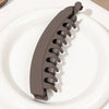 A set of five brown banana hair clips displayed on a white plate.