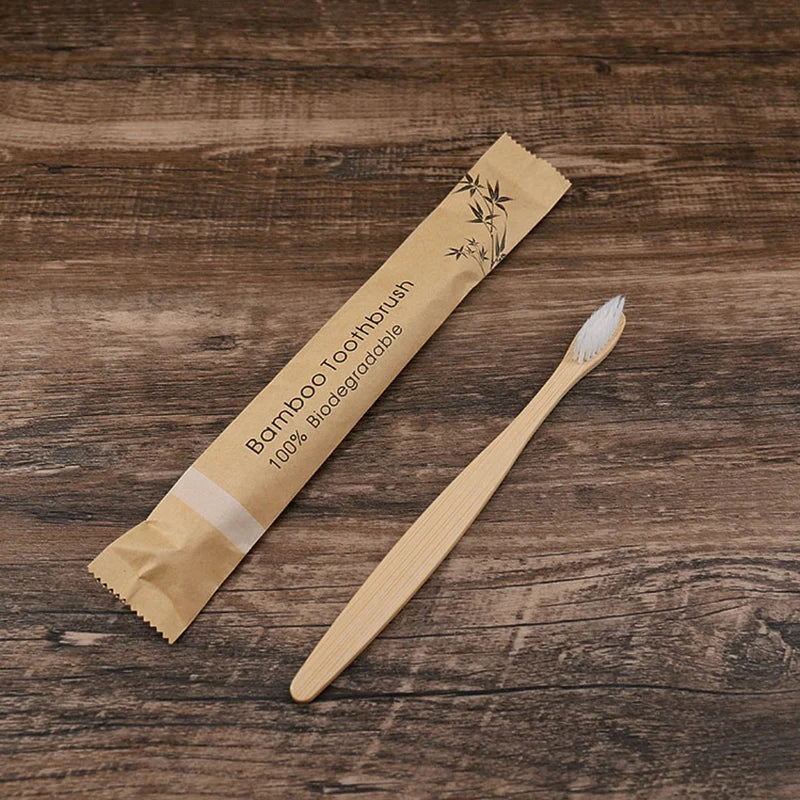 A bamboo toothbrush packaged in natural kraft paper on a wooden surface.