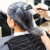 A person is using a reusable silicone hair dyeing cape and cutting collar to style their dark hair.
